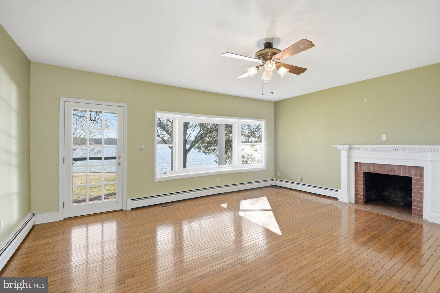 8515 Deep Cove Road Easton, MD 21601 - Photo 28 of 55 a view of an empty room with wooden floor fireplace and a window