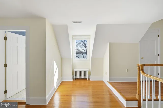 a view of a yard in front of a house with plants and large tree