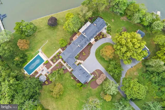 an aerial view of a house with a yard and lake view