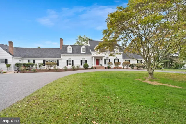 a front view of house with yard and trees all around