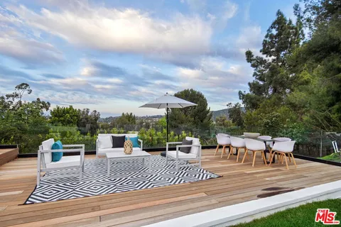 a view of a patio with dining table and chairs with wooden floor
