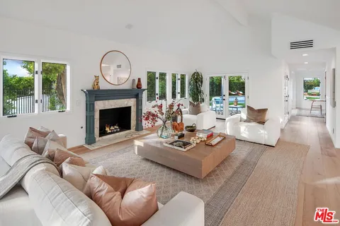 a living room with furniture a fireplace a large window and a large window