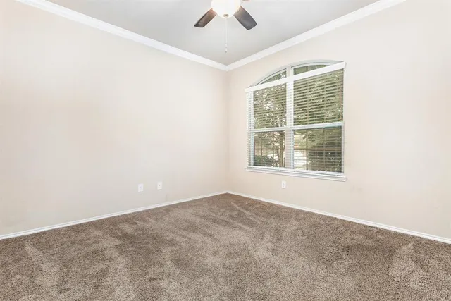 an empty room with a window and a fan