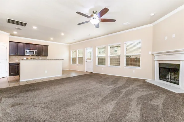a living room with furniture kitchen view and a large window
