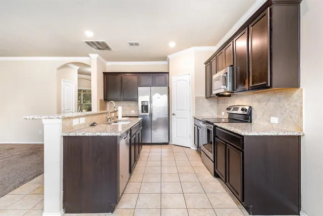 a kitchen with stainless steel appliances a refrigerator sink and microwave