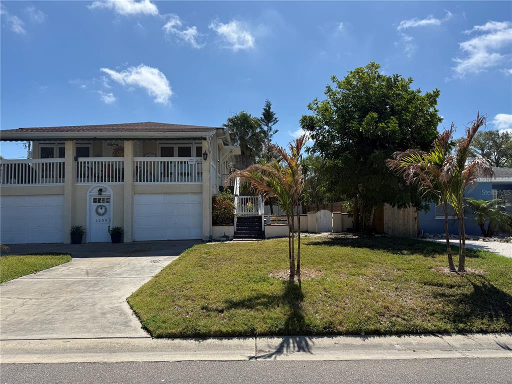 1209 1st Street Indian Rocks Beach, FL 33785 - Photo 1 of 8 a front view of a house with a yard