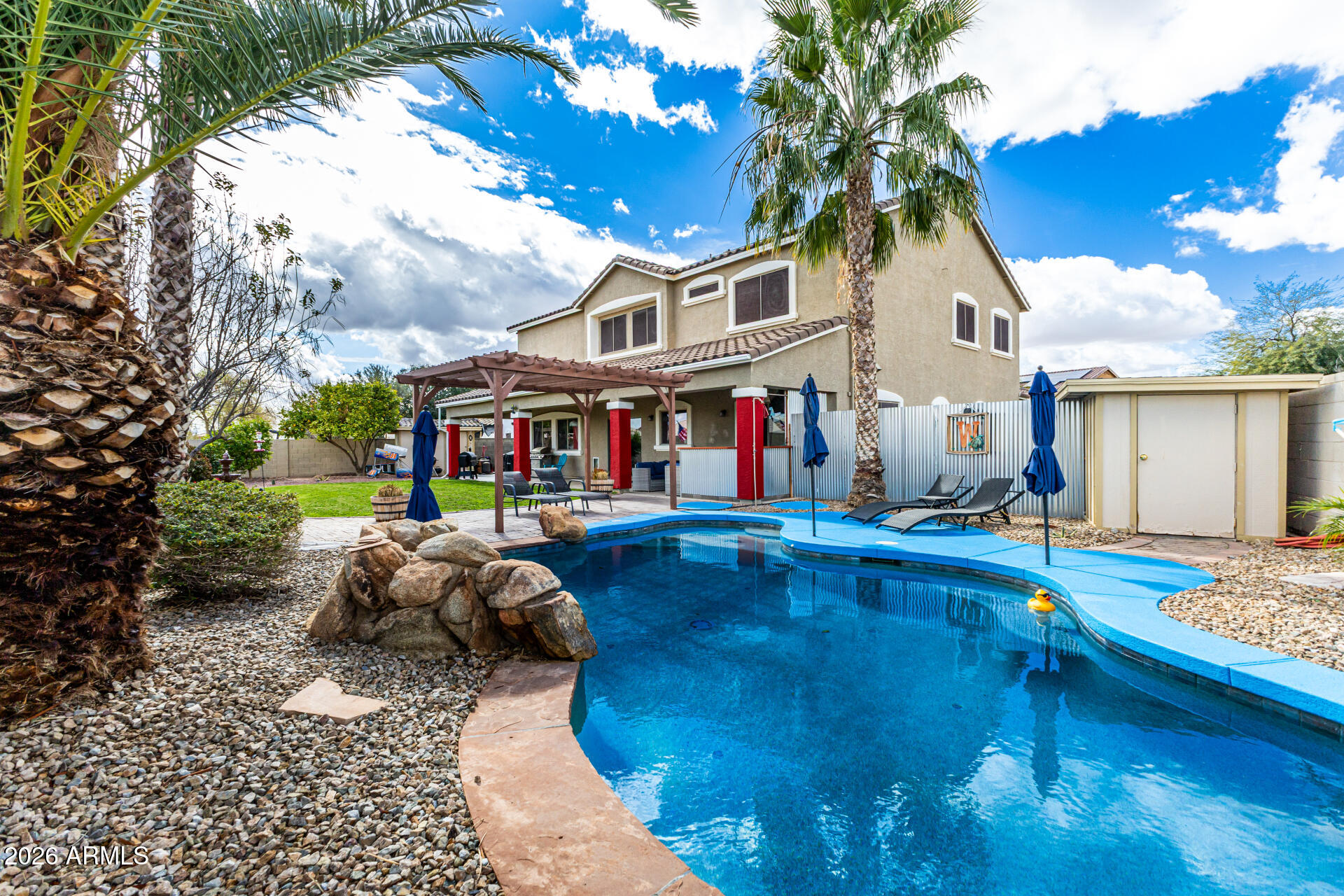 24541 Plum Road Florence, AZ 85132 - Photo 4 of 47 a view of swimming pool with lounge chair and dinning table under an white umbrella