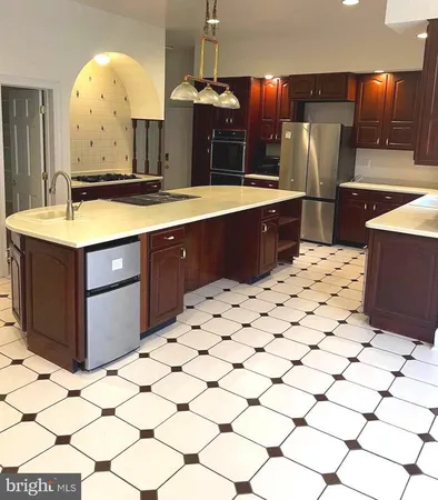 a kitchen with stainless steel appliances kitchen island granite countertop a refrigerator and a stove