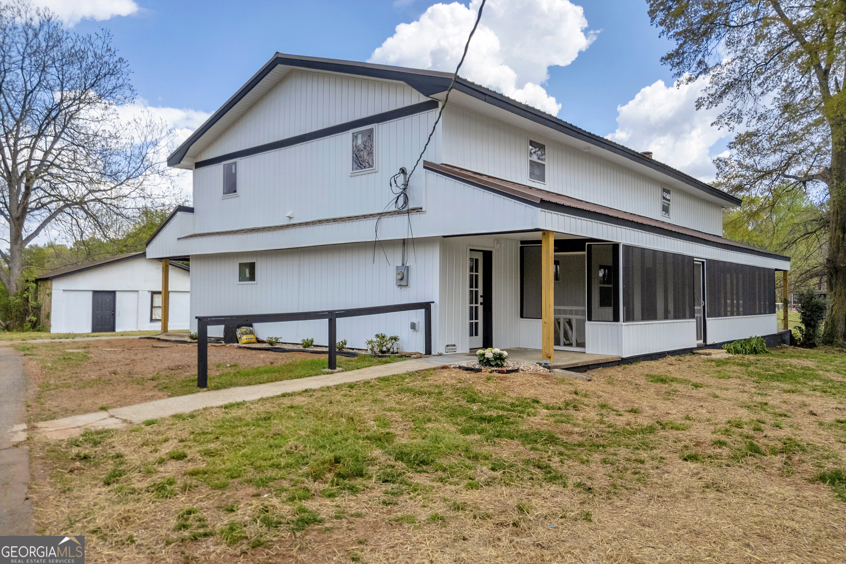 8606 Holly Springs Road Maysville, GA 30558 - Photo 12 of 74 a view of a house with large windows and a yard