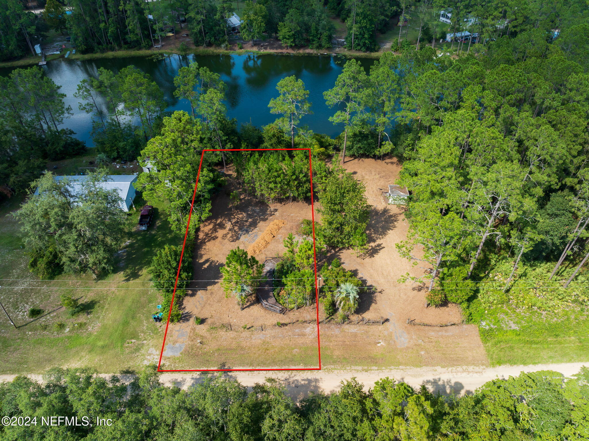 a view of a lake with a yard and large trees