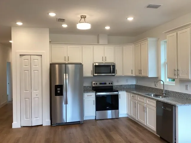 a kitchen with a refrigerator a sink and cabinets