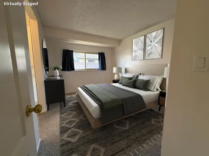 a bedroom with a bed and a dresser next to a window