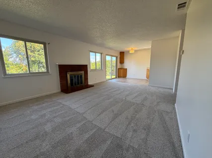 a view of a livingroom with a fireplace and window