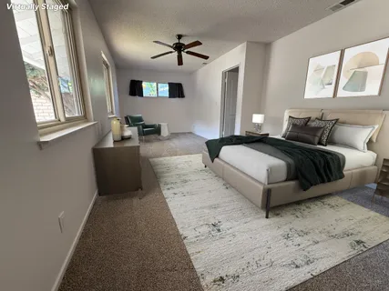 a bedroom with a bed lamp and wooden floor