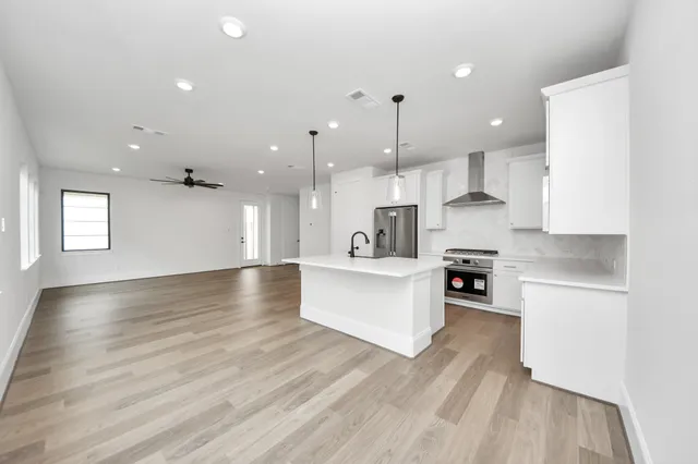 a view of kitchen with kitchen island sink stove and cabinets