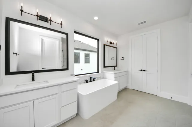 a bathroom with 2 sink tub and mirror