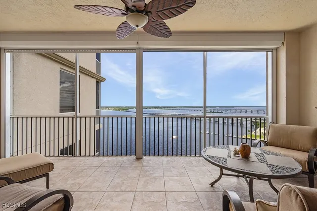a living room with furniture ceiling fan and a large window