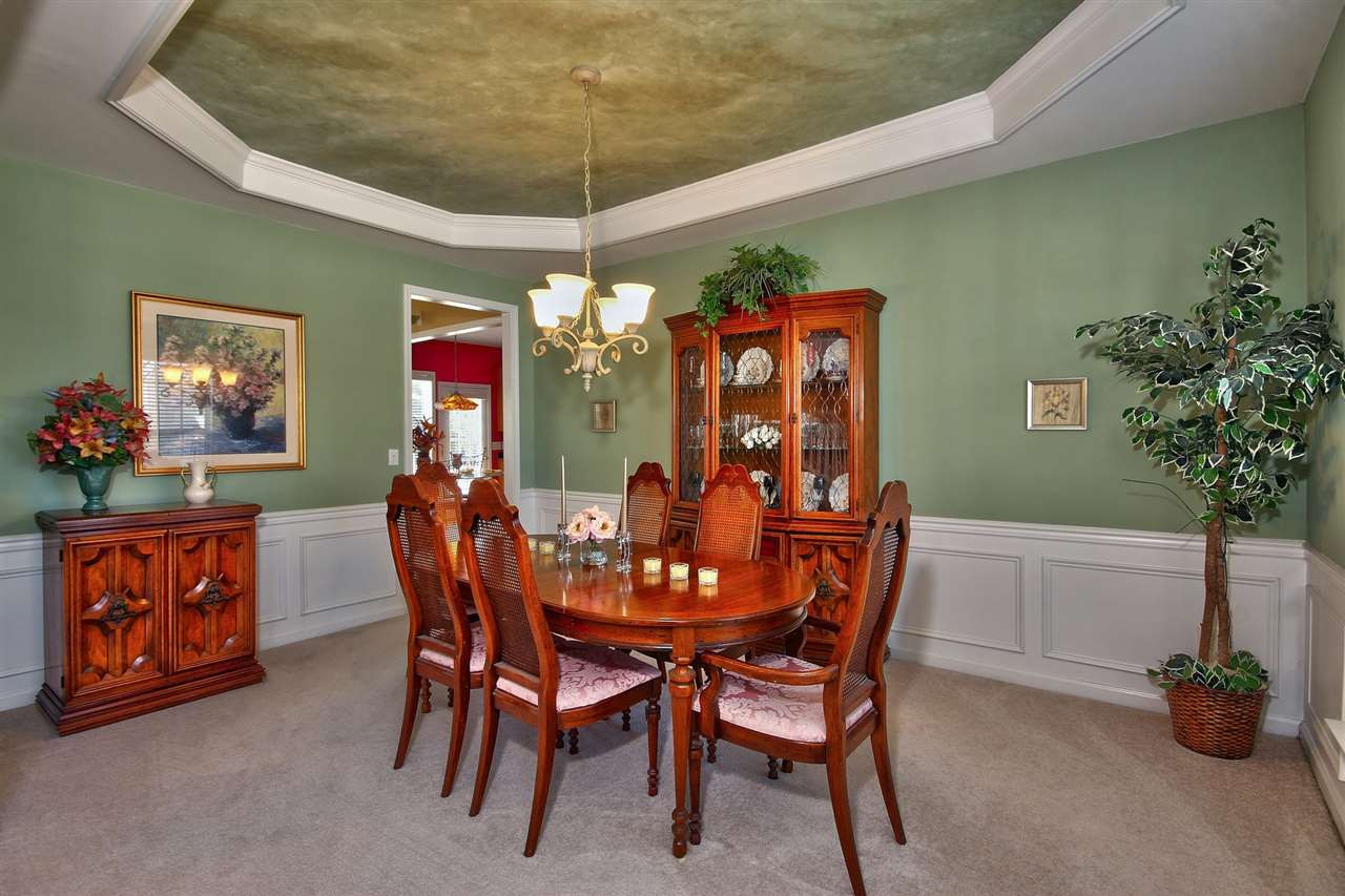 Spacious dining room offers a tray ceiling and wainscoting. Perfect for hosting a dinner party. Dining Room