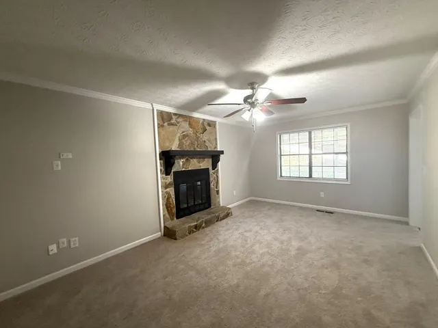 an empty room with windows and fireplace