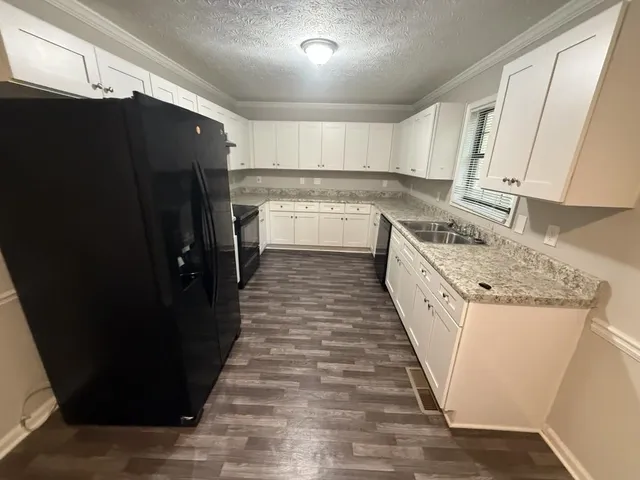 a kitchen with granite countertop a refrigerator and a sink