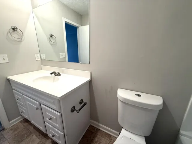 a bathroom with a sink toilet and mirror