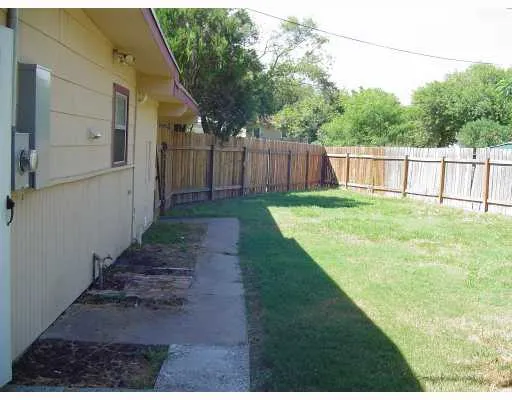 a view of a yard with wooden fence