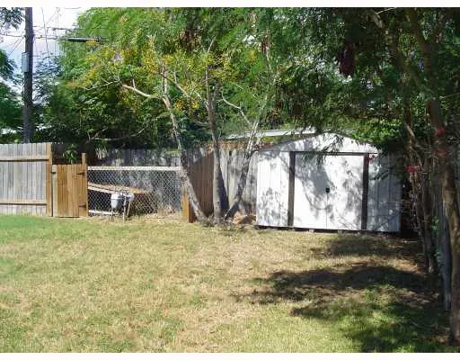 a view of a yard with wooden fence