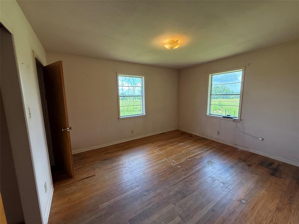 503 County Rd SE 4380 Scroggins, TX 75480 - Photo 17 of 40 an empty room with wooden floor and windows