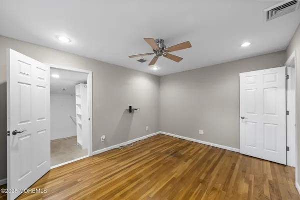 a view of a big room with wooden floor and a bathroom