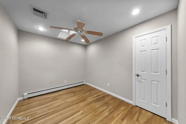 an empty room with a ceiling fan and wooden floor