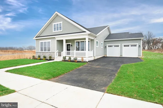 a front view of a house with a yard and trees