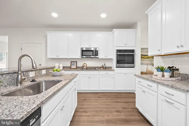 a kitchen with sink a microwave and cabinets