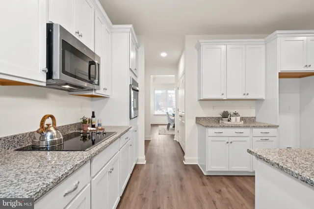 a kitchen with stainless steel appliances granite countertop a sink dishwasher stove and oven with wooden floor