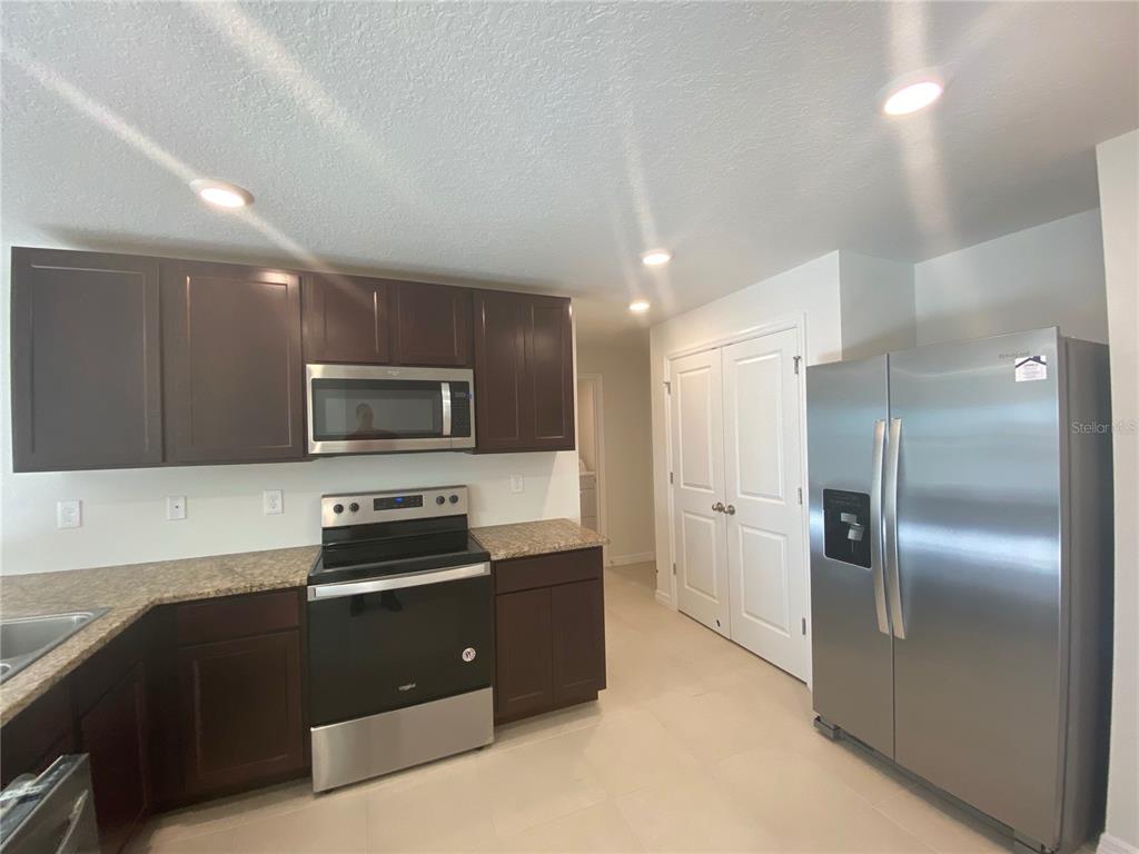 308 Hickory Course Radiel Ocala, FL 34472 - Photo 5 of 24 a kitchen with a refrigerator and a stove top oven
