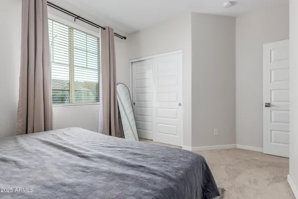 a bedroom with a bed and a large window