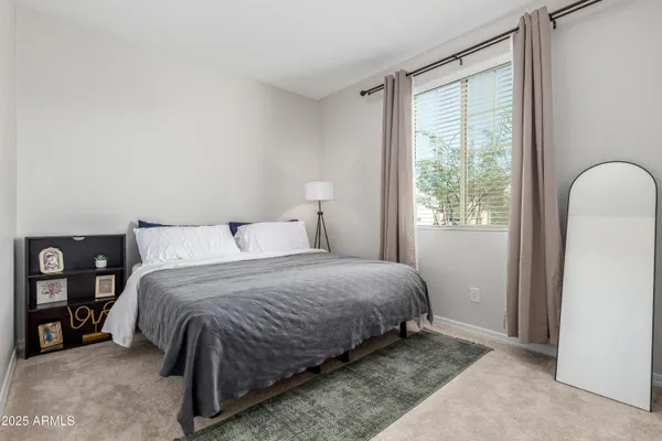 a bedroom with a bed next to a window