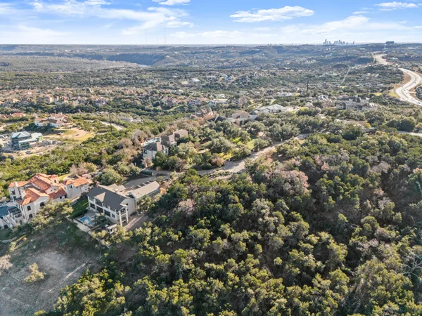 an aerial view of residential house with outdoor space and trees all around
