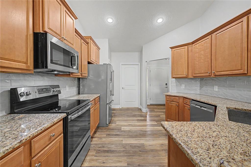 11213 Flock Avenue Weeki Wachee, FL 34613 - Photo 9 of 46 a kitchen with stainless steel appliances granite countertop a stove a sink and a microwave