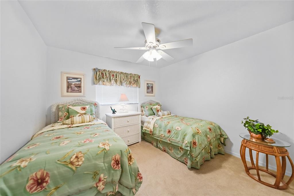 25225 Rampart Boulevard, Unit 1607 Punta Gorda, FL 33983 - Photo 22 of 48 a bedroom with two beds and a chandelier