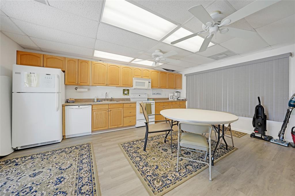 25225 Rampart Boulevard, Unit 1607 Punta Gorda, FL 33983 - Photo 41 of 48 a kitchen with a table chairs refrigerator and cabinets
