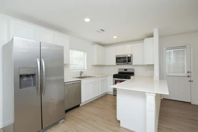 a kitchen with white cabinets and stainless steel appliances