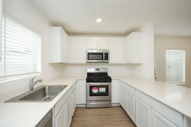a kitchen with a sink stove and microwave