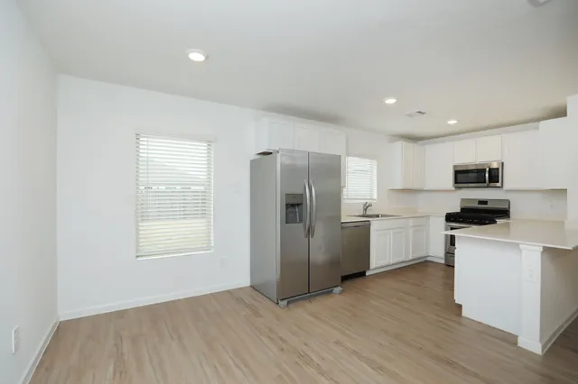 a kitchen with stainless steel appliances a refrigerator sink and microwave