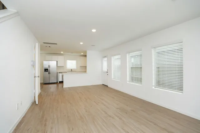 a view of a big room with wooden floor and windows