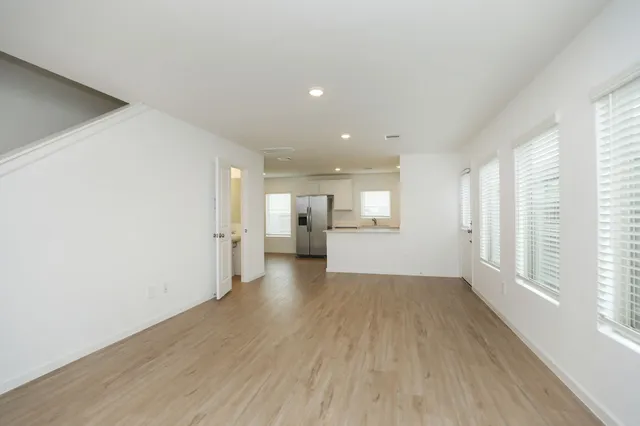 a view of a big room with wooden floor and windows