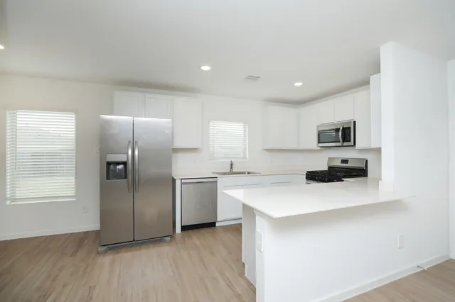 a kitchen with stainless steel appliances a refrigerator sink and microwave