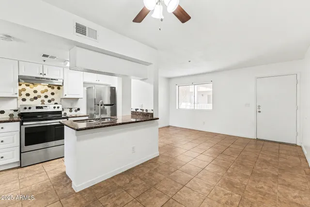 a kitchen with granite countertop a stove and a sink