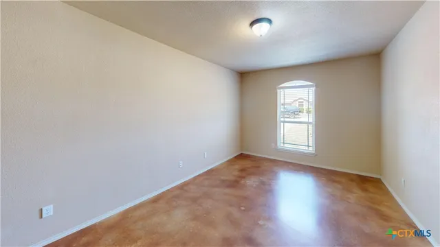 a view of an empty room with wooden floor and closet