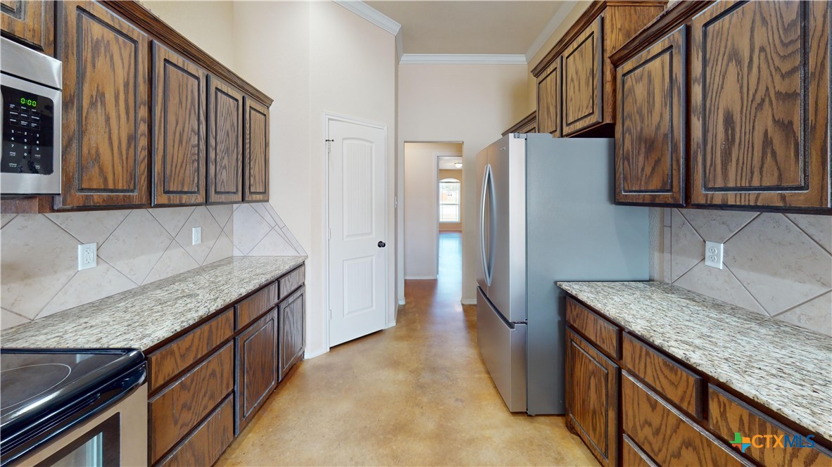 3401 Plateau Street Copperas Cove, TX 76522 - Photo 3 of 32 a kitchen with granite countertop a refrigerator and a sink