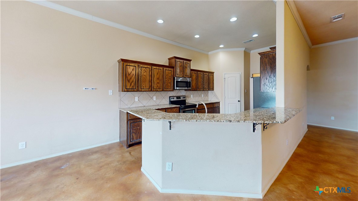 3401 Plateau Street Copperas Cove, TX 76522 - Photo 4 of 32 a kitchen with stainless steel appliances a refrigerator and a stove